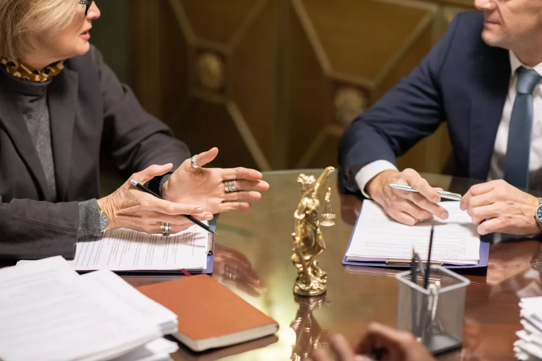 two-experienced-lawyers-formalwear-interacting-by-workplace