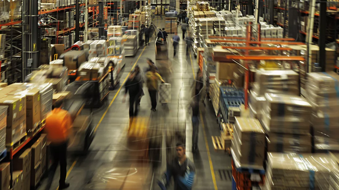 large-warehouse-with-people-moving-down-aisle